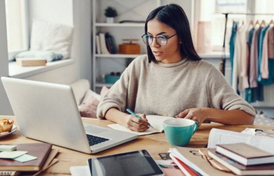 Woman working remote on a cluttered desk